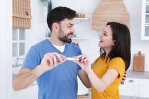 happy couple seeing their pregnancy test result